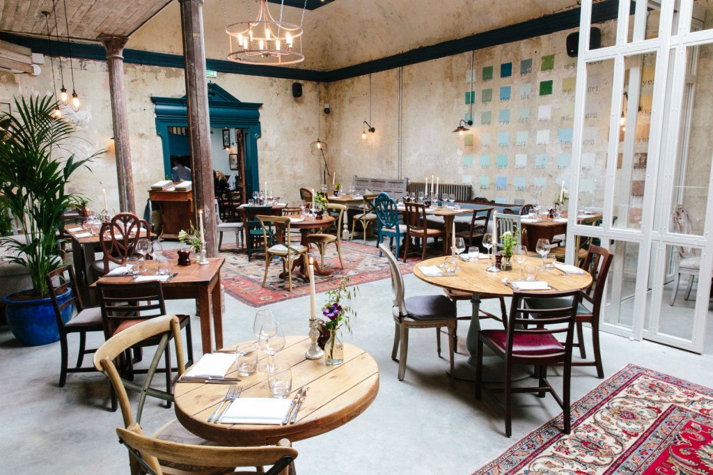 Industrial warehouse meets faded grandeur: the dining room. Photo: PR