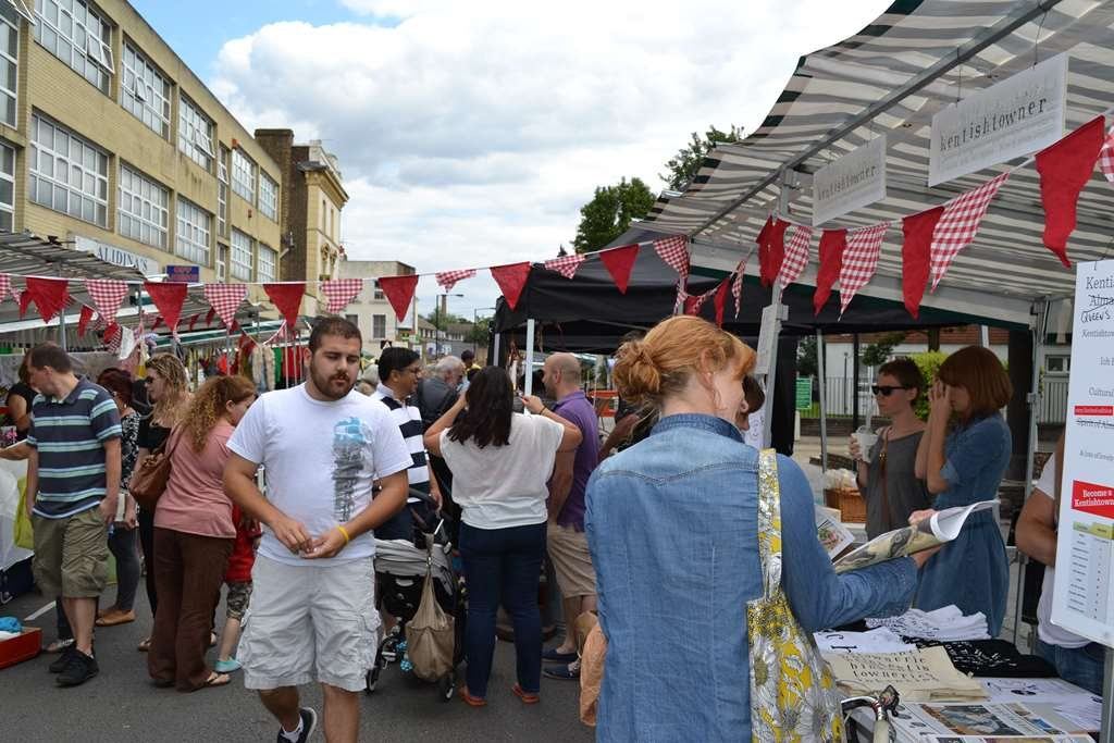 People browsing at Queen's Crescent Street Party with red bunting