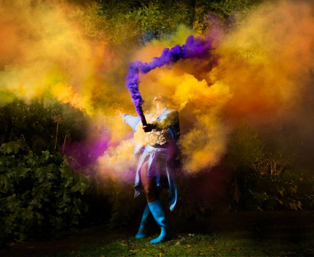 Shakespeare performer concealed by colourful smoke